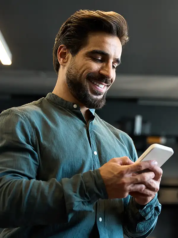 Man smiling while using smartphone